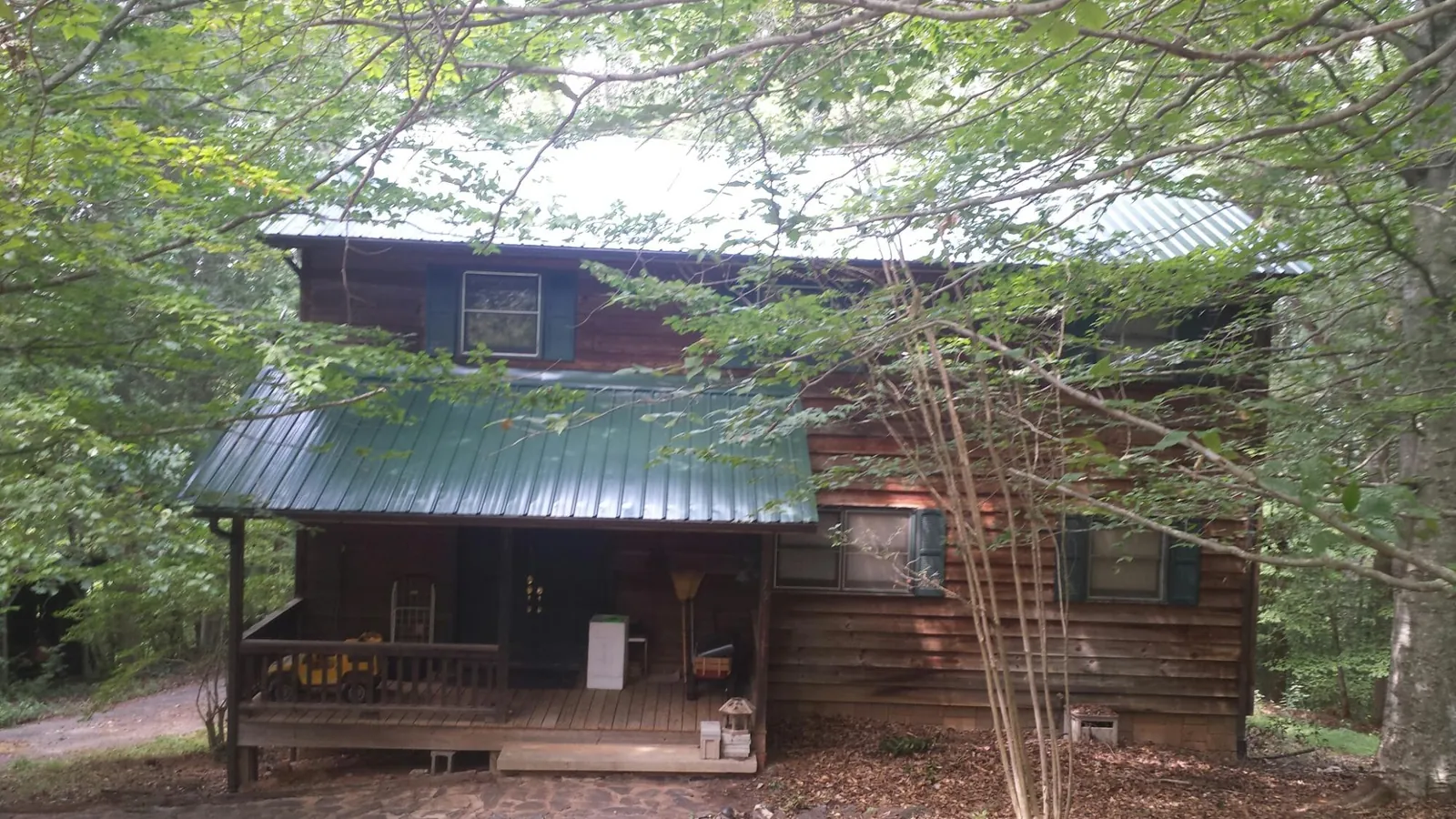 Green metal roof and covered porch on a log cabin in Ketchum