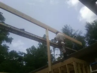 Carpenter setting a ridge beam over a new addition frame — Ice Dam Removal by Roofing Brothers in Ketchum