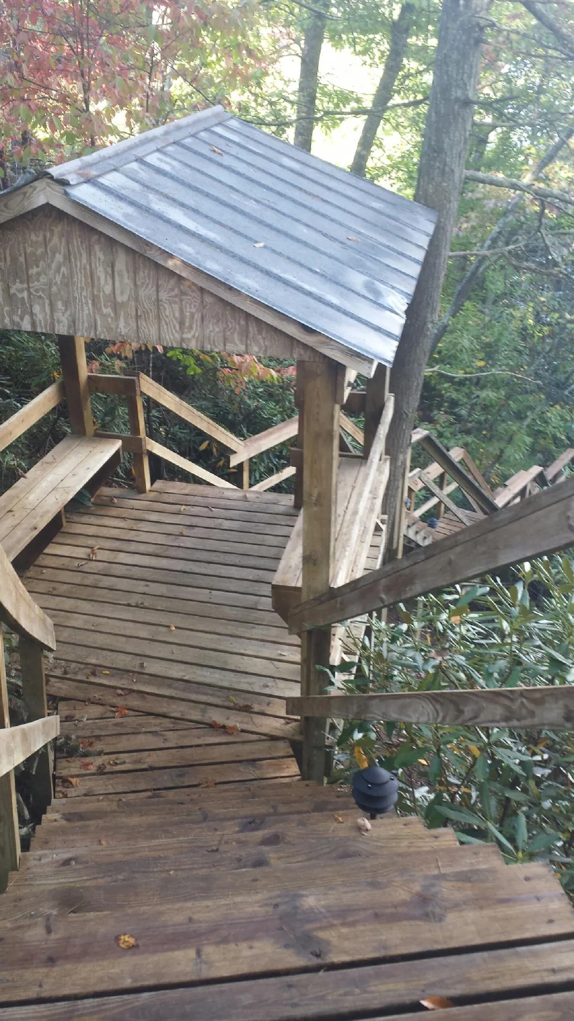 Metal roofed shelter over wooden steps on a wooded walkway — Skylight Repair & Installation work by our crew in Ketchum