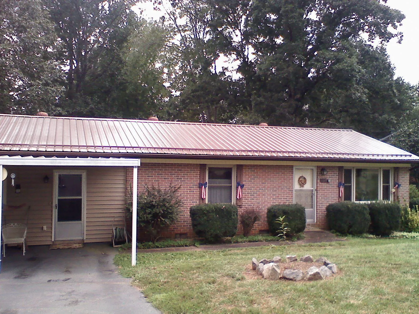 Bronze metal roof and carport on a brick ranch home — Roof Repair work by our crew in Ketchum